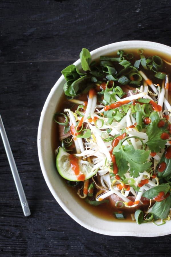 Easy Pho recipe: fragrant beef broth, slices of beef, rice noodles, sprouts, cilantro and basil, hot peppers, and a squeeze of lime!