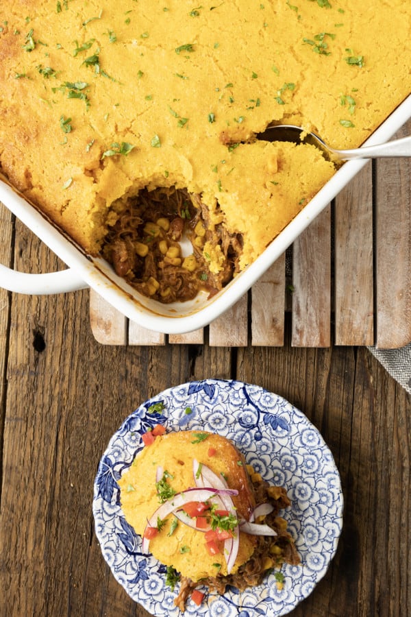 This satisfying, comforting Pulled Pork Casserole lets you get a dinner the whole family will love on the table even on busy weeknights. Saucy, succulent pulled pork with tender black beans and sweet corn is baked under golden brown cornbread in this easy casserole. Serve it alone or topped with all sorts of taco goodies like sour cream, grated cheese, onions, tomatoes, avocado, and taco sauce.