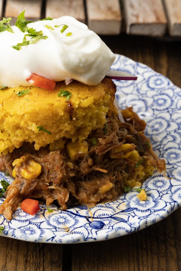 This satisfying, comforting Pulled Pork Casserole lets you get a dinner the whole family will love on the table even on busy weeknights. Saucy, succulent pulled pork with tender black beans and sweet corn is baked under golden brown cornbread in this easy casserole. Serve it alone or topped with all sorts of taco goodies like sour cream, grated cheese, onions, tomatoes, avocado, and taco sauce.