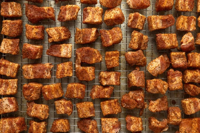 A cooling rack filled with pieces of meat.