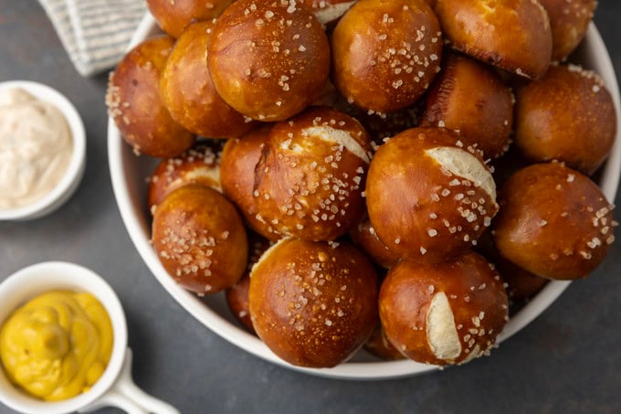 sourdough discard soft pretzel bites in a bowl with mustard and queso