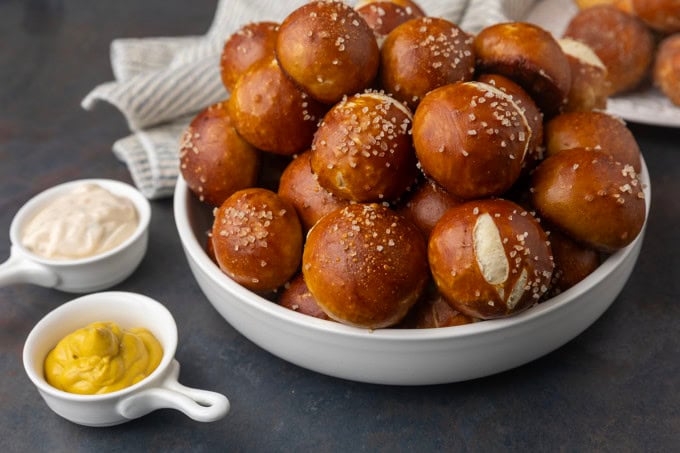 A bowl filled with pretzels and mustard.