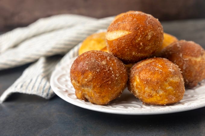 A plate of cinnamon sugar pretzel bites on a table with a napkin.