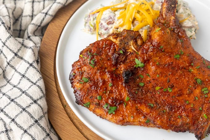 thin cut pork chop cooked in the air fryer on a plate with potato salad
