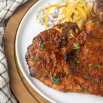 thin cut pork chop cooked in the air fryer on a plate with potato salad