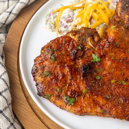 thin cut pork chop cooked in the air fryer on a plate with potato salad