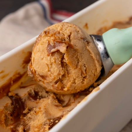 A scoop of ice cream is being scooped into a bowl.