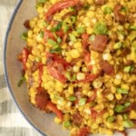 fried sweet corn with bacon, green onions and roasted red peppers in a bowl