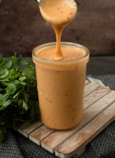pouring bang bang sauce into a jar