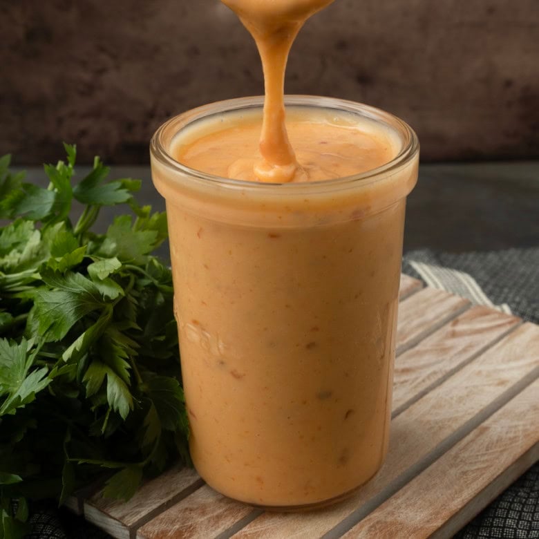 pouring bang bang sauce into a jar