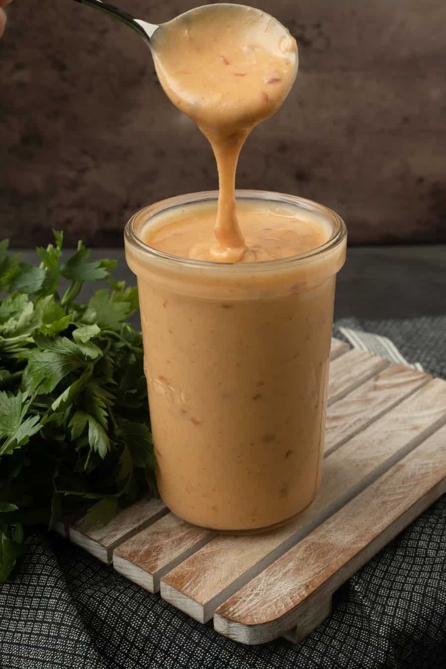 pouring bang bang sauce into a jar