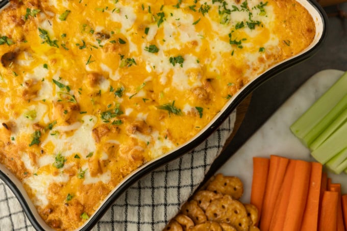 Buffalo chicken dip with crackers and carrots.