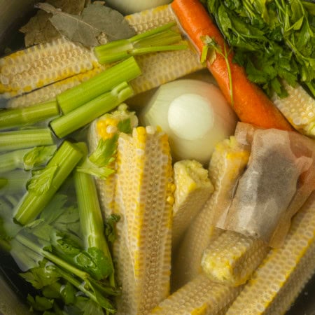corn cobs and vegetables in a stockpot to make corn stock