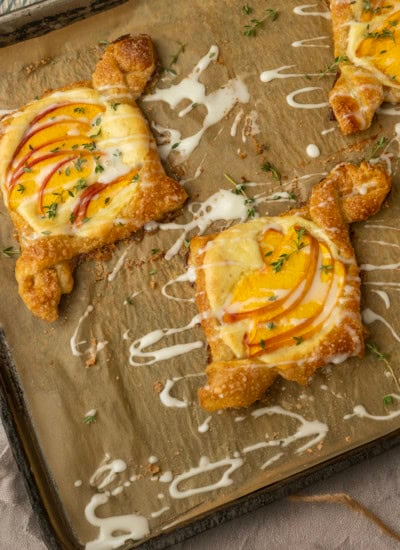 peach cream cheese puff pastry with thyme on parchment lined pan