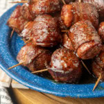 air fryer kielbasa bites wrapped with bacon drizzled with honey on a blue plate