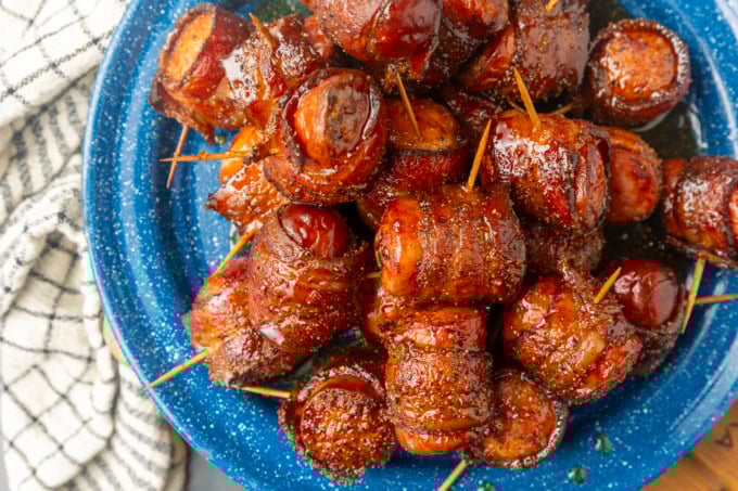 air fryer kielbasa bites wrapped with bacon drizzled with honey on a blue plate