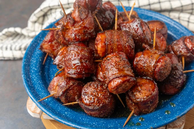 air fryer kielbasa bites wrapped with bacon drizzled with honey on a blue plate