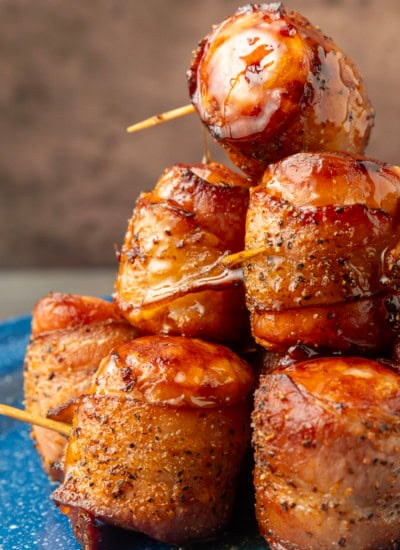 air fryer kielbasa bites wrapped with bacon drizzled with honey on a blue plate