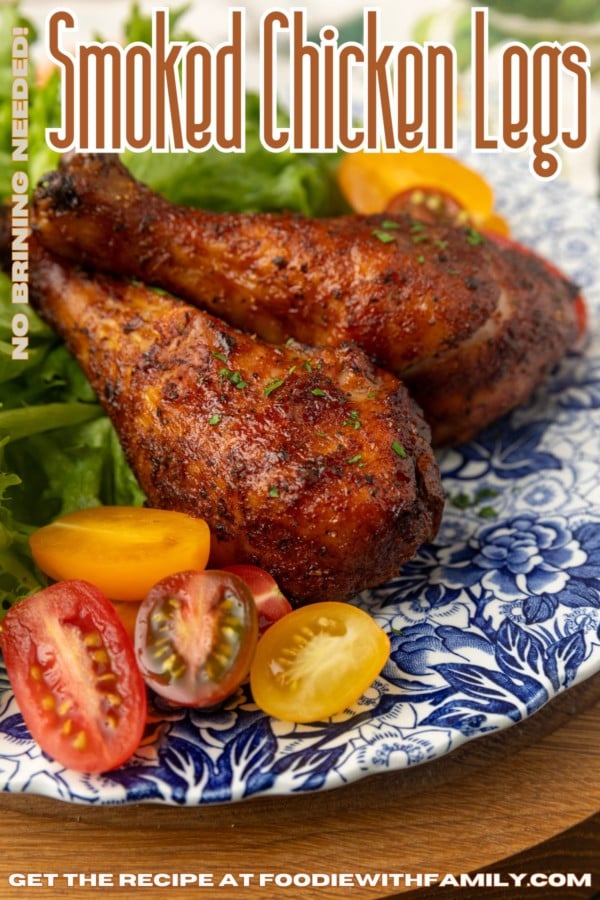 smoked chicken drumsticks on a blue and white plate with cherry tomatoes and text describing the photograph