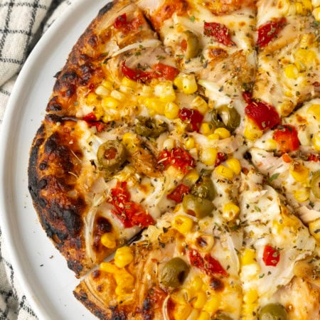 tuna pizza with corn, olives, onions, and roasted red peppers