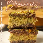 Viral Dubai Chocolate Brownies on parchment paper and stacked on a plate with text overlay describing the photo