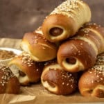 pretzel dogs on parchment paper on a pan with a variety of dipsa