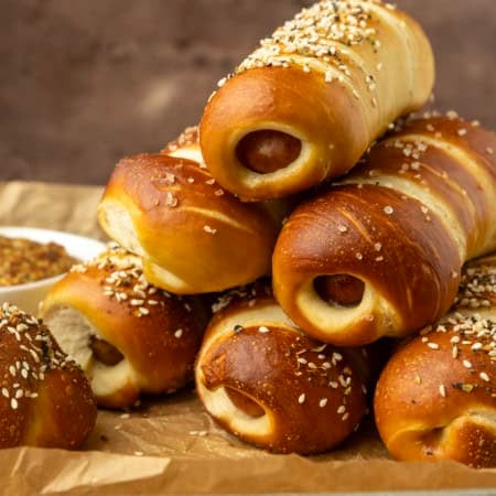pretzel dogs on parchment paper on a pan with a variety of dipsa