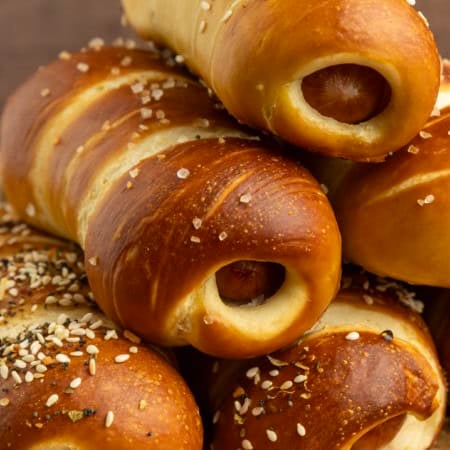 pretzel dogs on parchment paper on a pan with a variety of dipsa