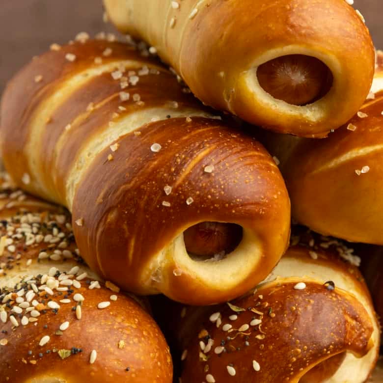 pretzel dogs on parchment paper on a pan with a variety of dipsa