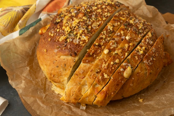 partially sliced one hour rosemary parmesan bread on parchment paper