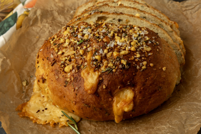 partially sliced one hour rosemary parmesan bread on parchment paper