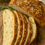 partially sliced one hour rosemary parmesan bread on parchment paper