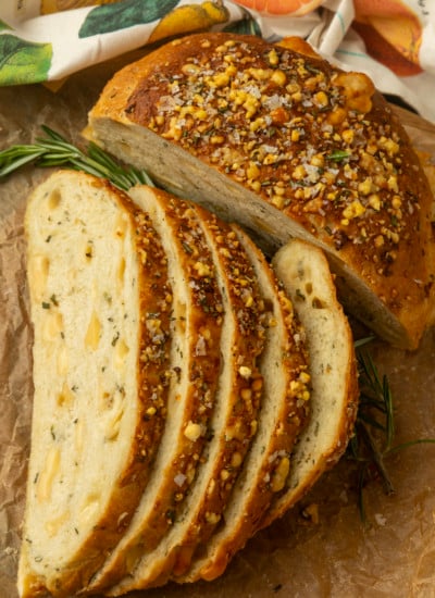 partially sliced one hour rosemary parmesan bread on parchment paper