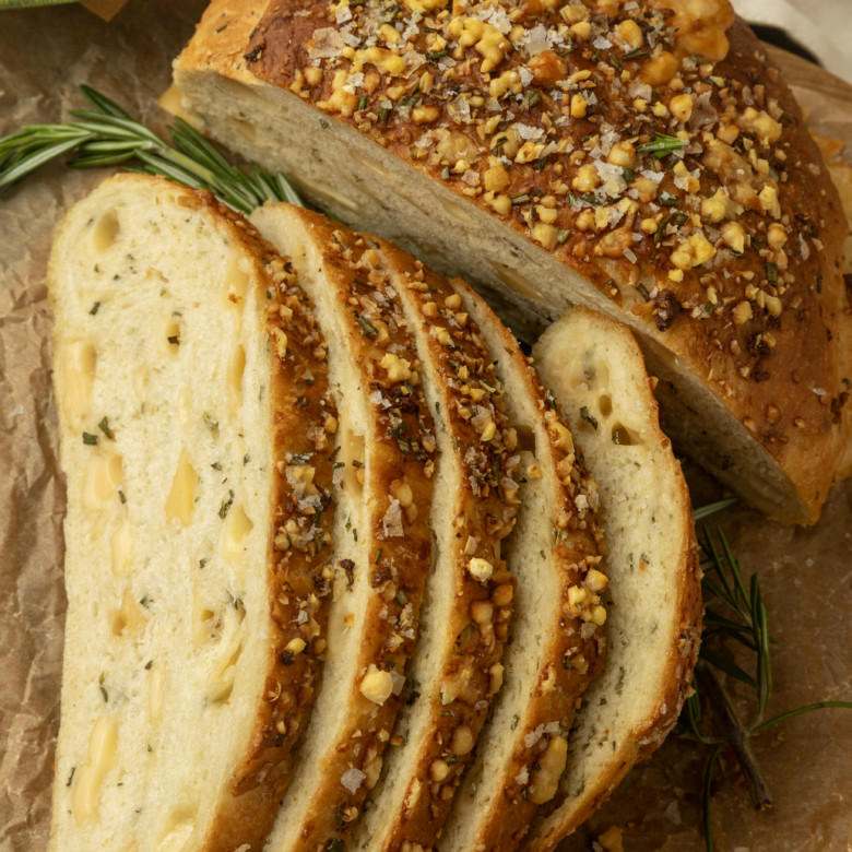 partially sliced one hour rosemary parmesan bread on parchment paper