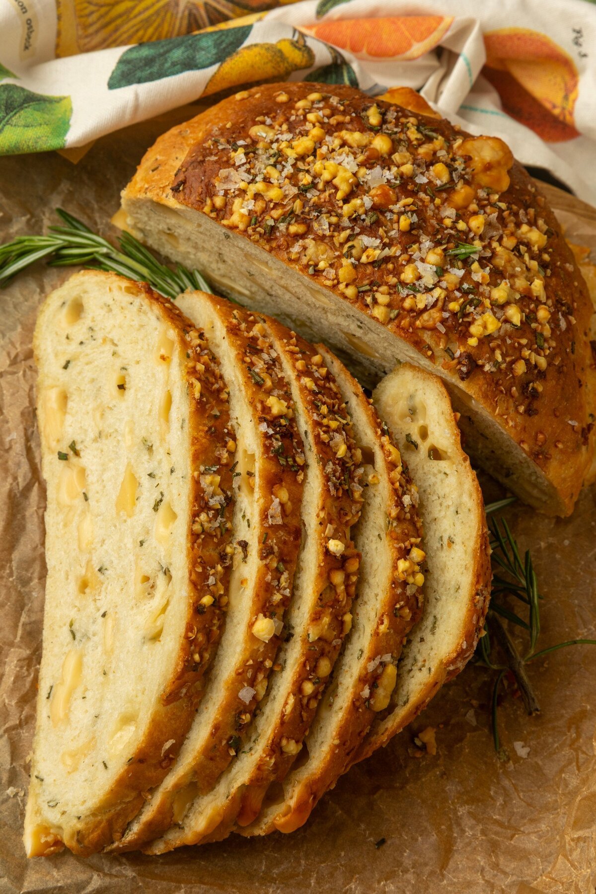 partially sliced one hour rosemary parmesan bread on parchment paper