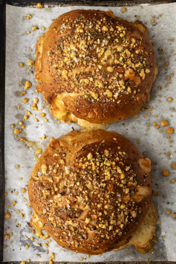 two loaves of rosemary parmesan bread on a parchment lined sheet pan