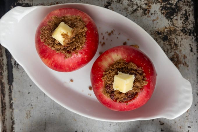 apples stuffed with brown sugar, butter, and dried cranberries in ramekins