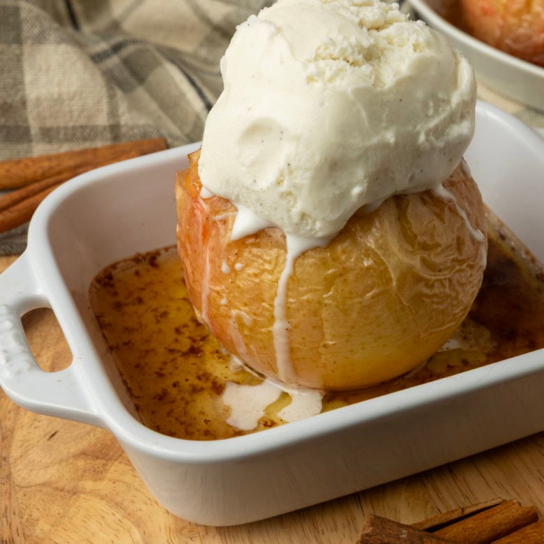 apples stuffed with brown sugar, butter, and dried cranberries in ramekins, baked, topped with vanilla ice cream