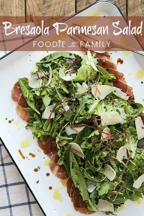 Bresaola Parmesan Salad on white quarter sheet pan with cobalt blue rim, blue and white tea towel, antique fork, rustic wood tabletop, pinterest title banner