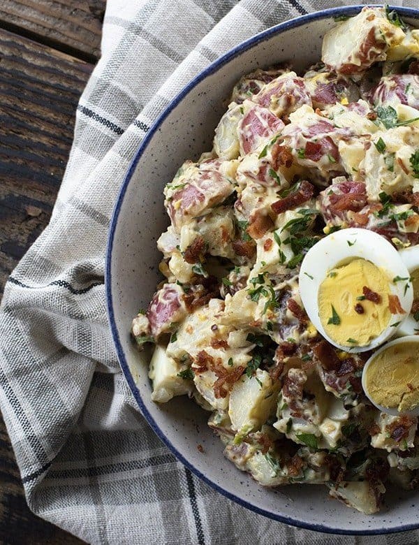 This next level potato salad has a full pound of crispy bacon, a creamy dressing with a hint of Dijon mustard, fresh herbs, hard boiled eggs, and tender potatoes. It's sure to be your new favourite potato salad for grilling and picnic season.