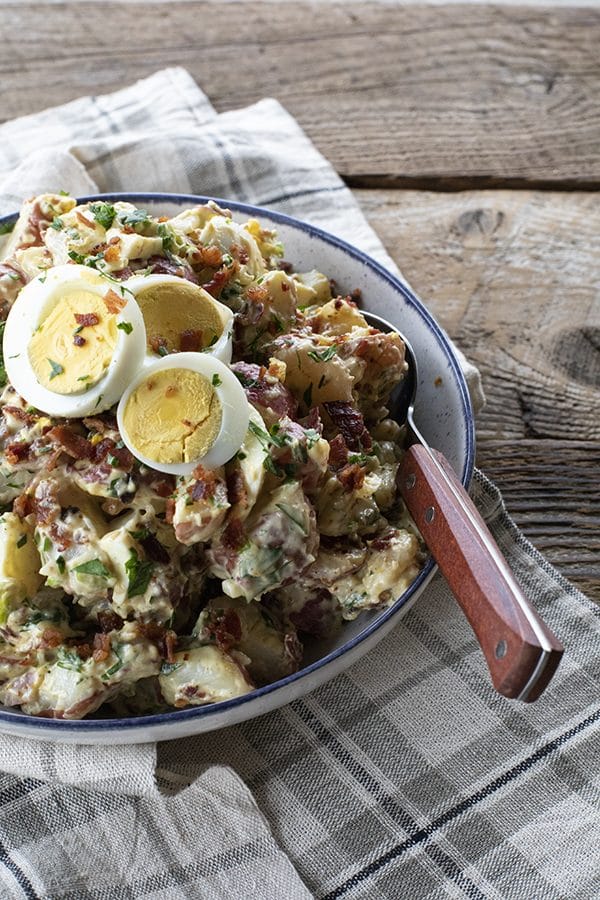 This next level potato salad has a full pound of crispy bacon, a creamy dressing with a hint of Dijon mustard, fresh herbs, hard boiled eggs, and tender potatoes. It's sure to be your new favourite potato salad for grilling and picnic season.