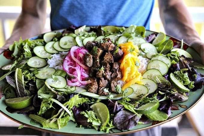 Bo Luc Lac -Shaking Beef- is a spectacularly fresh and flavourful Viêtnamese salad of mixed greens, cucumbers, pickled red onions, juicy mango, tender rice vermicelli noodles, bright herbs, and an irresistible black pepper lime dressing.