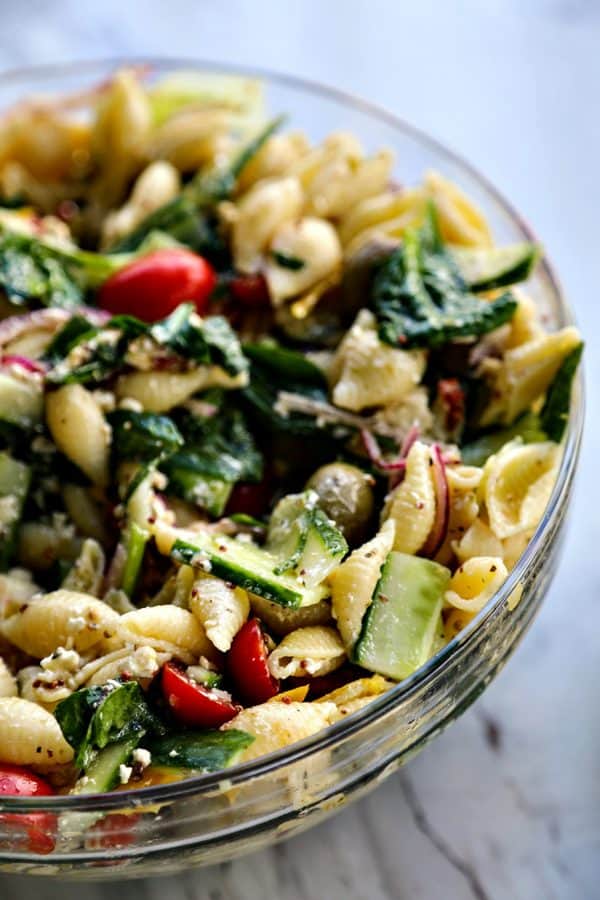 Vegetable lovers rejoice! This Veggie Lover's Greek Pasta Salad is absolutely bursting with baby spinach, cucumbers, tomatoes, bell peppers, Greek olives, and red onions all in a tantalizing garlicky herbed lemon dressing.