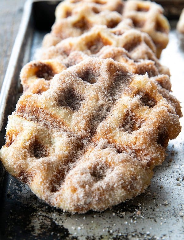 Crispy edged, cinnamon-sugar dusted Churros Waffles are 100% irresistible and ridiculously easy to make, taking advantage of frozen dough for the base. Bonus: No boiling oil!