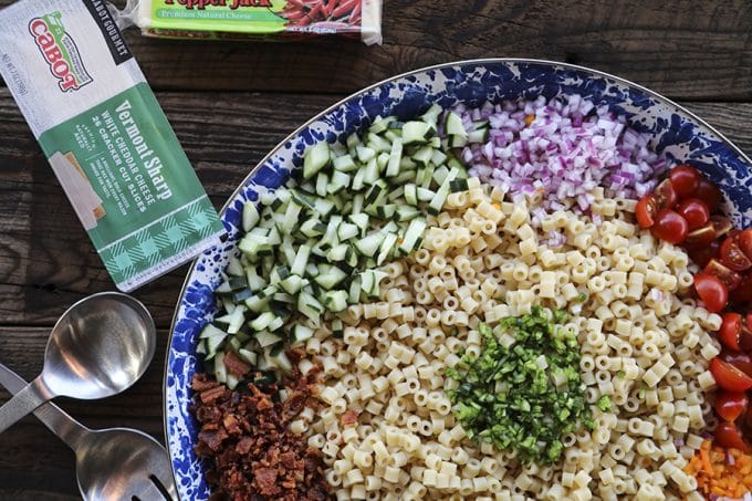 Tender, little ditalini, crunchy yellow and orange bell pepper, cucumber, crispy bacon crumbles, tiny cubes of Cheddar and pepper jack cheese, and minced fresh jalapeño pepper and chives in a creamy ranch dressing make this Spicy Bacon Cheddar Pasta Salad recipe scream summer!