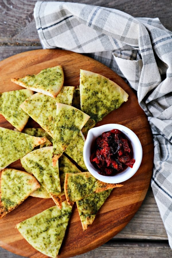 Crispy, crunchy, perfect pesto brushed homemade pita chips are as easy as cut, brush, bake and make a great snack or salad accompaniment.