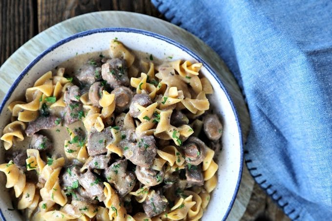 Instant Pot Garlic Beef Stroganoff: creamy, extra garlicky, mushroom and onion gravy enrobing tender beef cubes, with perfect pasta all cooked together in the Instant Pot. This has to be one of the most simple, crave-worthy comfort foods ever to be adapted to the world of electric pressure cookers.