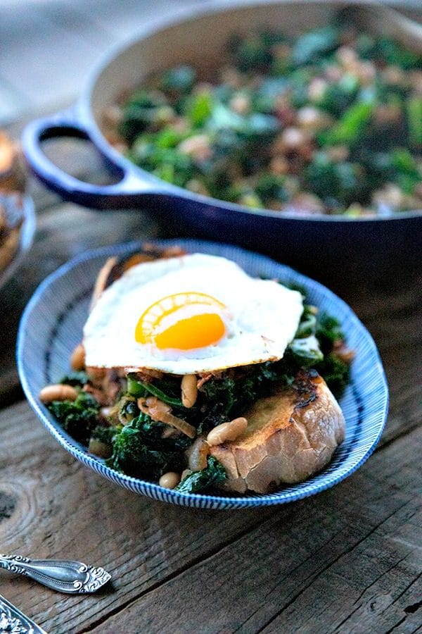 Tender beans and greens, caramelized onions, savoury bacon, sliced garlic, smoked paprika, and a hint of spice, star in this one-pot, low cost, crowd-pleaser served over indulgently thick slices of crunchy-edged, pan toasted garlic bread.