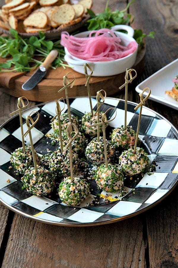 These gorgeous little two-bite, miniature cheese balls are dressed up with smoked salmon, chives, and everything bagel seasoning and taste like New York City when served with bagel chips, pickled red onions, and capers.
